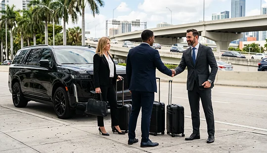 A professional chauffeur in a suit shakes hands with a businessman on a city sidewalk next to several pieces of luggage. A businesswoman stands nearby holding her handbag next to a parked black luxury SUV, with a highway overpass in the background.
