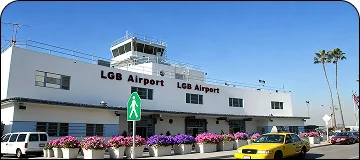 Entrance to Long Beach Airport (LGB) terminal with palm trees and modern architecture for BUR to Long Beach car service.