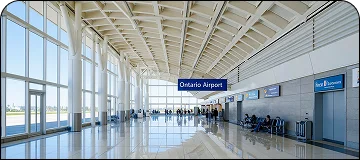 Modern terminal facade of Ontario International Airport (ONT) with passenger drop-off area for BUR to Ontario car service.