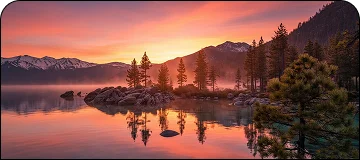 A scenic view of Lake Tahoe surrounded by mountains, pine trees, and calm water.
