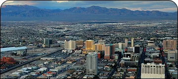 An aerial view of a sprawling cityscape with a mountain range in the distance.