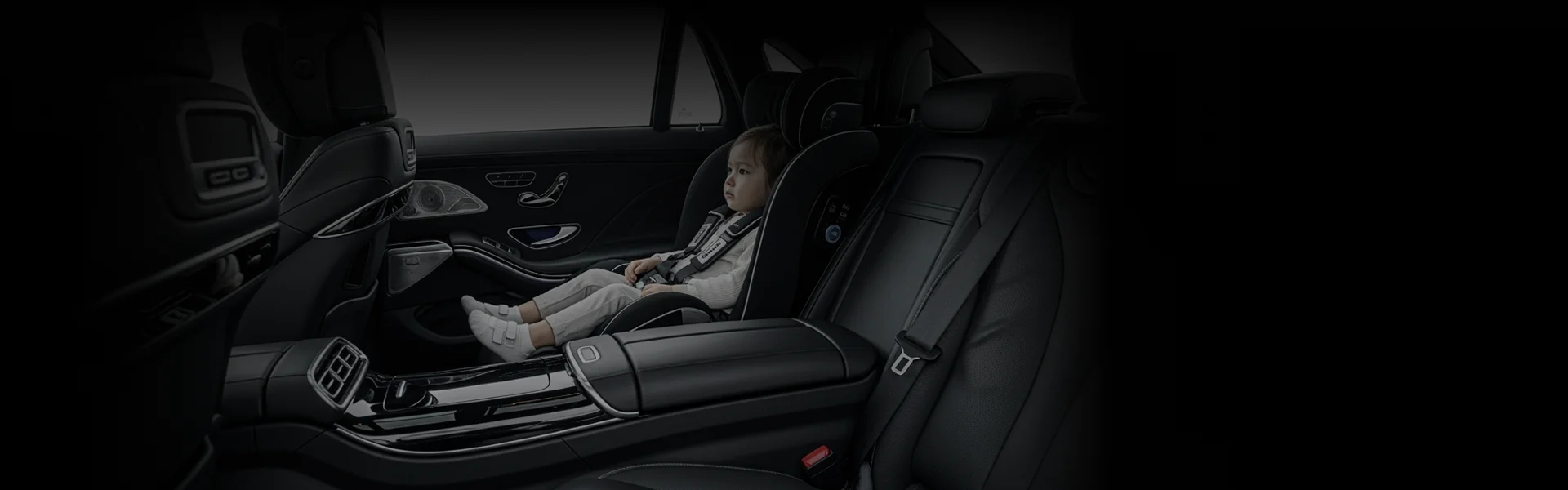 Child securely seated in a car seat behind the driver inside a luxury vehicle, highlighting LA car service with child seat option.